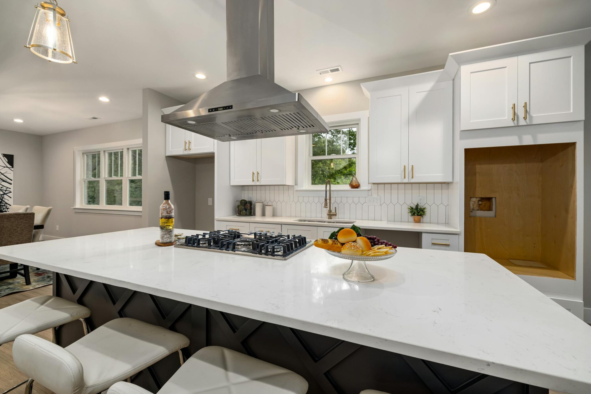 Sleek modern kitchen with white cabinets, island, and stainless range hood for a contemporary look.
