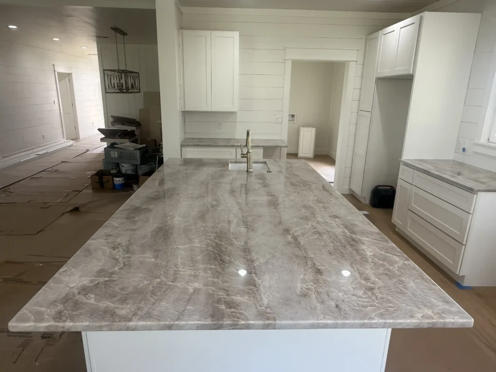 Luxury granite countertops installation in Sugar Land TX kitchen, close-up of black granite kitchen countertop with beveled edge, polished granite countertop surface with natural veining nearby Sugar Land TX, granite island with waterfall edge installed in Sugar Land TX, custom granite bathroom vanity top near Sugar Land TX, modern white quartz countertops in Sugar Land TX home remodel, durable quartz kitchen countertops with gray veining nearby Sugar Land TX, sparkling quartz surface on center island installed in Sugar Land TX kitchen, quartz countertops with undermount sink in Sugar Land TX kitchen remodel, custom-cut quartz countertop slab ready for installation near Sugar Land TX, elegant marble bathroom countertops installed in Sugar Land TX, Calacatta marble kitchen countertops near Sugar Land TX, high-end white marble island in Sugar Land TX luxury home, marble slab with bold veining at countertop showroom nearby Sugar Land TX, classic honed marble countertop surface in Sugar Land TX bathroom, natural quartzite kitchen countertops in Sugar Land TX, luxurious quartzite island countertop near Sugar Land TX, textured quartzite bathroom vanity top installed in Sugar Land TX home, quartzite countertops with edge detail in Sugar Land TX remodel, gray and white quartzite slab ready for fabrication nearby Sugar Land TX, expert countertop installer placing quartz in Sugar Land TX home, granite countertop fabrication process at local shop near Sugar Land TX, installing custom countertops in a kitchen renovation near Sugar Land TX, stone countertop delivery and installation crew in Sugar Land TX, countertop fabricators measuring for quartz installation in Sugar Land TX, granite, marble, and quartz slabs on display in Sugar Land TX showroom, customers selecting quartzite slab for countertops in Sugar Land TX, close-up of countertop edge profiles at showroom near Sugar Land TX, Silestone and Cambria quartz samples available in Sugar Land TX showroom, full-slab natural stone selection for countertops near Sugar Land TX, kitchen remodel with new quartz countertops in Sugar Land TX, bathroom renovation with custom marble vanity top nearby Sugar Land TX, open-concept kitchen with new granite countertops installed in Sugar Land TX, home remodel featuring waterfall edge countertops near Sugar Land TX, before and after countertop renovation project in Sugar Land TX, Texas Rockstar Granite offers affordable custom countertops in Sugar Land TX, low monthly payment countertop financing available near Sugar Land TX, locally trusted countertop experts serving Sugar Land TX and nearby areas, customer reviewing granite samples at Texas Rockstar Granite Sugar Land TX, professional countertop team finishing kitchen install in Sugar Land TX home.