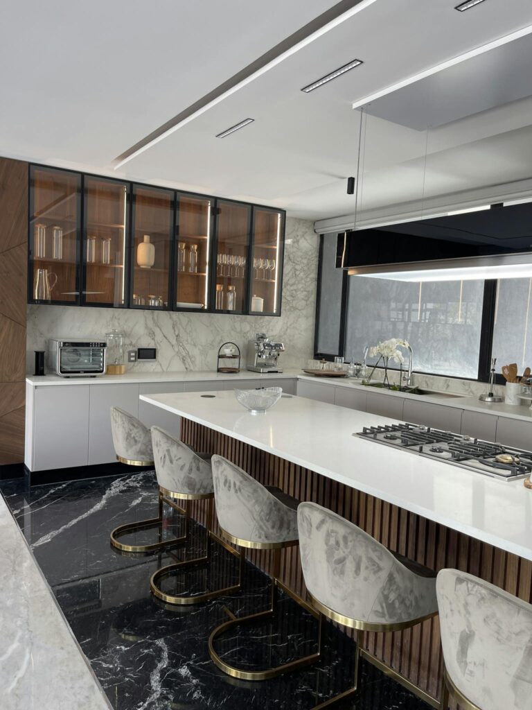 Elegant kitchen featuring a marble island, modern seating, and sleek cabinetry. Quartz countertops Granite countertops Quartzite countertops Marble countertops