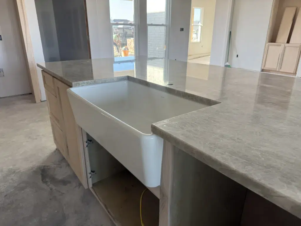 Taj Mahal Quartzite countertop island with farmhouse sink