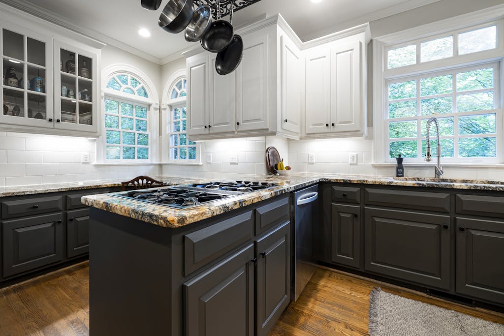 Spacious kitchen featuring granite countertops, white cabinets, and stainless steel appliances.